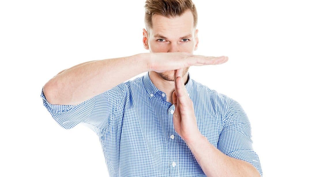 Mann nimmt sich Auszeit und macht Time-out-Zeichen