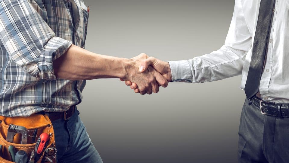 Handwerker und Bauherr schütteln sich die Hand