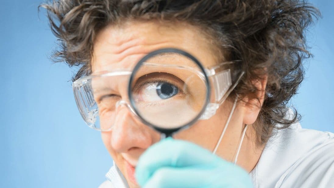 verrückter Professor nimmt etwas unter die Lupe
Crazy  scientist looks through a magnifying glass