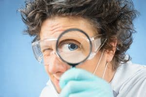 verrückter Professor nimmt etwas unter die Lupe
Crazy  scientist looks through a magnifying glass