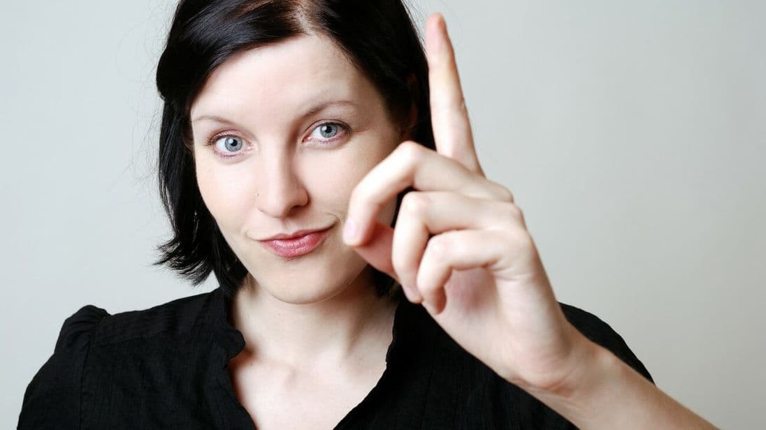 Frau erhebt ihren Zeigefinger