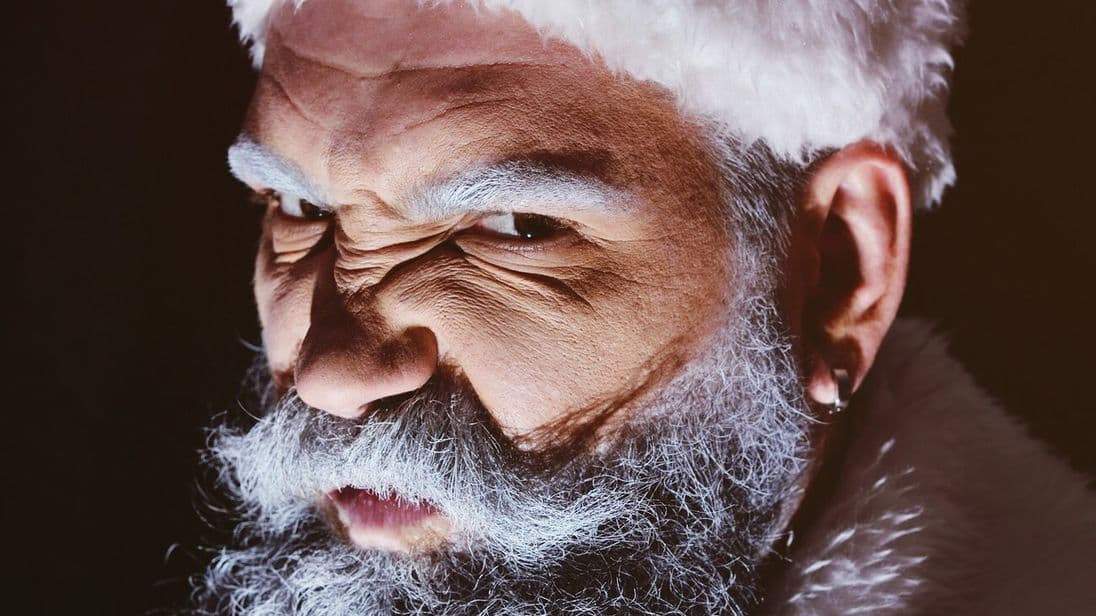 Angry Santa furiously grimaces against a dark background