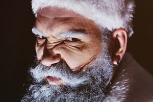 Angry Santa furiously grimaces against a dark background