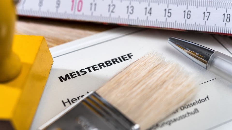 Meisterprüfungszeugnis mit Zollstock, Stempel und Kugelschreiber