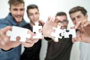 group of young people with puzzle pieces.the concept of solving the problem