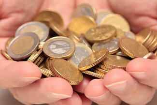 Eine Person hält eine Hand voll Euro-Münzen